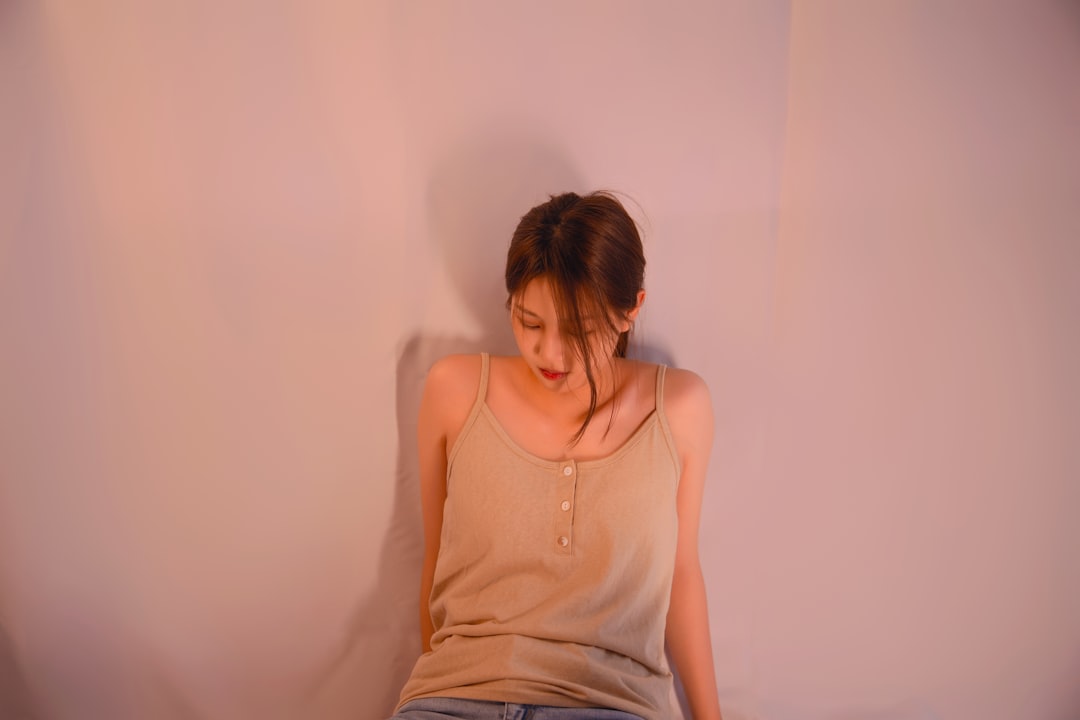 Người phụ nữ ngồi trầm tư, nhìn ra cửa sổ, ánh mắt buồn bã, thể hiện nỗi đau ly hôn.